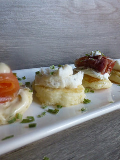 Una foto de Canapés de blinis con jamón, queso, salmón, salsa de yogur y brandada de bacalao