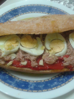 Una foto de Bocadillo de pimientos rojos asados con ajitos, atún y huevo