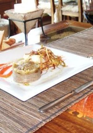 Una foto de Merluza negra sobre coulis de pimientos del piquillo acompañada de puré de lentejas y compota de hinojos