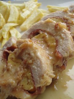 Una foto de Pechuga de pollo rellena de jamón, queso y tortilla en salsa de vino y cebolla