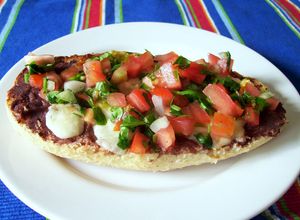 Una foto de Molletes con frijoles refritos y pico de gallo