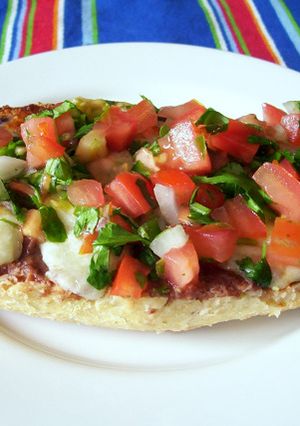 Una foto de Molletes con frijoles refritos y pico de gallo