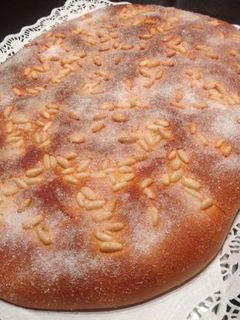 Una foto de Coca de brioche con piñones