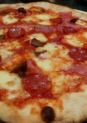 Una foto de Pizza masa casera con chorizo, jamón, queso y aceitunas