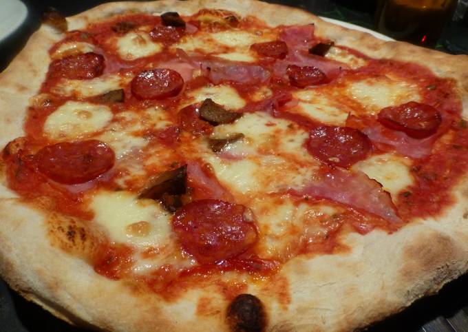 Foto principal de Pizza masa  casera  con chorizo, jamón, queso  y aceitunas