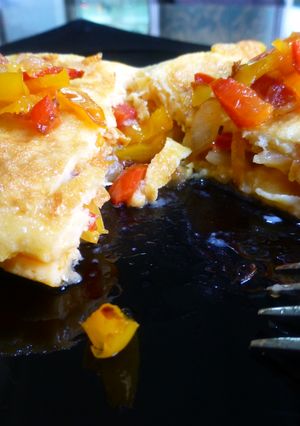 Una foto de Tortilla francesa rellena de pimiento rojo y amarillo