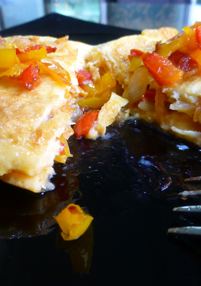 Una foto de Tortilla francesa rellena de pimiento rojo y amarillo