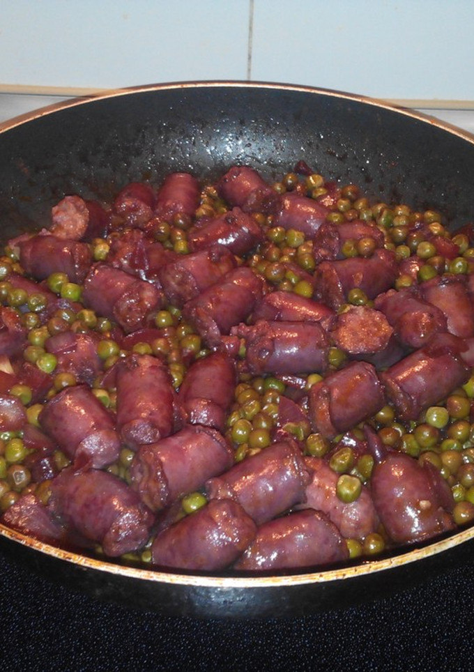 Una foto de Salchichas frescas al vino tinto con guisantes