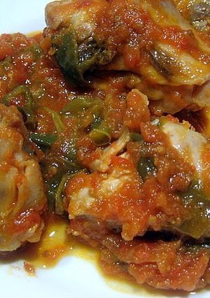 Una foto de Pollo con tomate y pimientos verdes