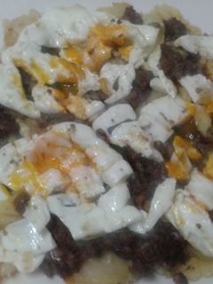 Una foto de Patatas a lo pobre con morcillas y huevos rotos