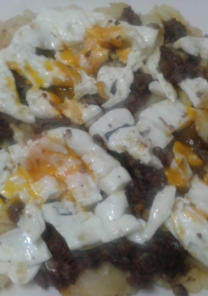 Una foto de Patatas a lo pobre con morcillas y huevos rotos