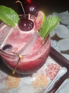 Una foto de Limonada con cerezas y hojas de menta