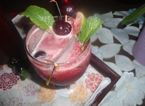 Una foto de Limonada con cerezas y hojas de menta