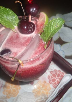 Una foto de Limonada con cerezas y hojas de menta