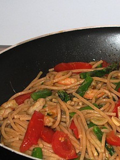 Una foto de Spaguetti salteados con espárragos, gambas y tomates
