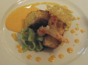 Una foto de Lomo de corvina con heliscristo, crujiente de queso de cabra y tallarines de choco