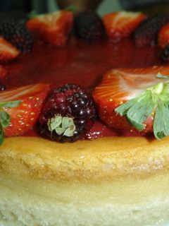 Una foto de Cheesecake con cubierta de fresa y mora