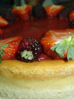 Una foto de Cheesecake con cubierta de fresa y mora