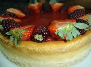Una foto de Cheesecake con cubierta de fresa y mora