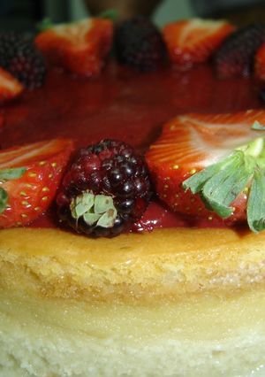 Una foto de Cheesecake con cubierta de fresa y mora