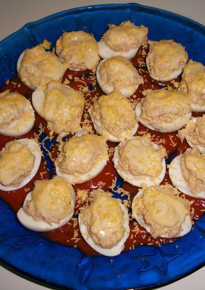 Una foto de Huevos rellenos de atún en cama de salsa de tomates