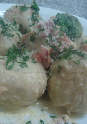 Una foto de Gnochis de papa rellenos de mozzarella, crema de ajos y jamón crudo