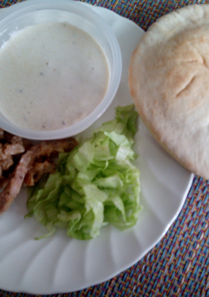 Una foto de Gyros con salsa de yogur