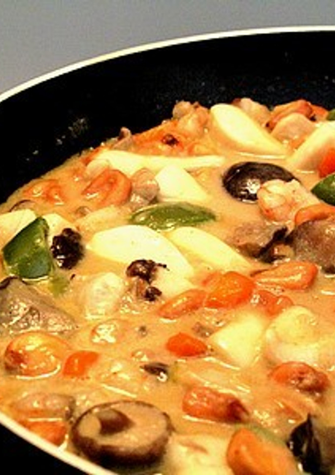 Una foto de Encocada de sepia y setas con verduras y maíz en Wok