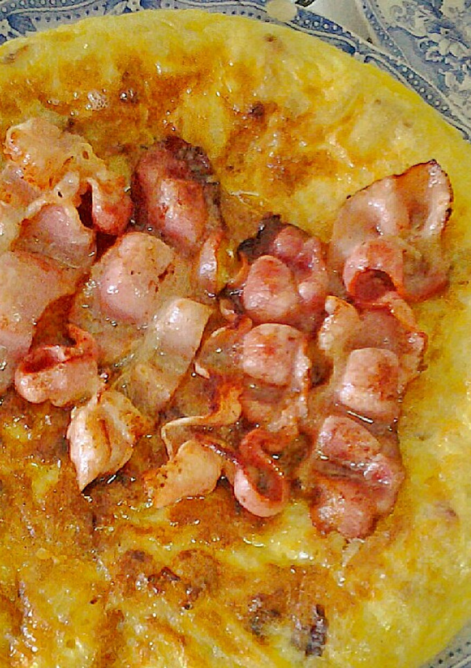 Una foto de Tortilla de patatas con bacón y su jugo por encima