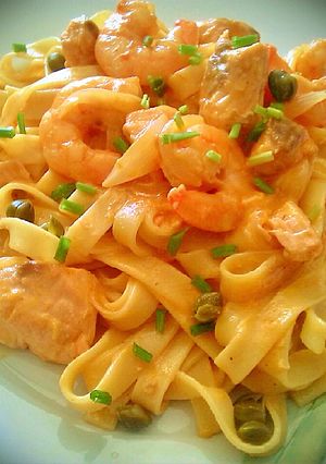 Una foto de Tallarines con salmón fresco, langostinos y alcaparras