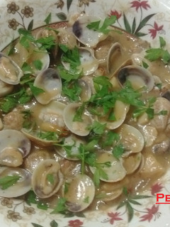 Una foto de Almejas con piñones y vino al limón