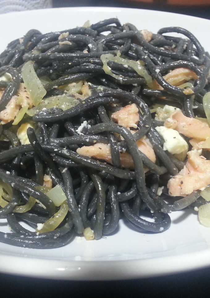 Una foto de Espaguetis al nero di sepia con salmón ahumado y queso feta