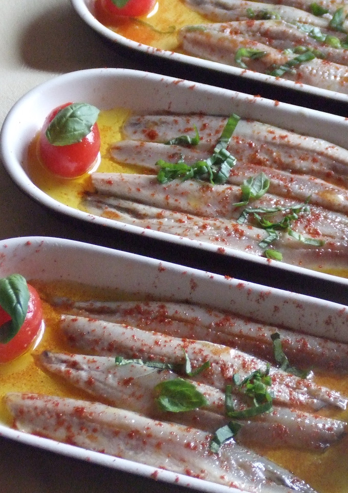 Una foto de Aperitivo de boquerones en vinagre con tomatitos y albahaca
