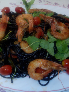 Una foto de Pasta negra con langostinos y verduras