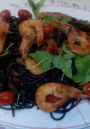 Una foto de Pasta negra con langostinos y verduras