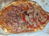 Pizza casera mitad de atún y pimiento, mitad de bacon y cebolla