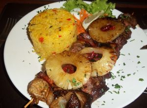 Una foto de Brochettes tropicales con timbal de arroz frito