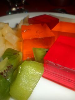 Una foto de Gelatina moldeada y frutas al plato