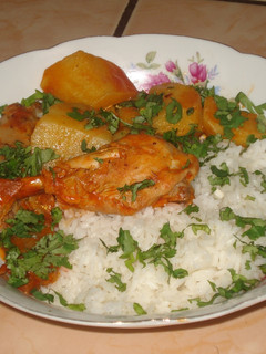 Una foto de Pollo con papas en salsa de tomate