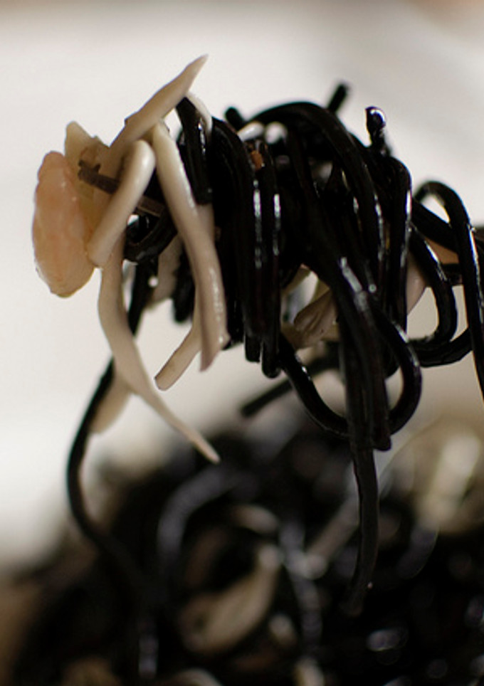 Una foto de Tagliatelle nero con gula y gambas