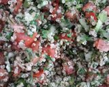 A picture of step 4 of Tabbouleh with white quinoa seed.