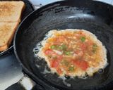 A picture of step 3 of Schezwan chutney brown Bread 🍞 tomato 🍅 onion omellete.