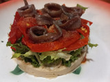 Ensalada de hummus, pimientos asados y anchoas