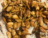 A picture of step 7 of Tray bake pumpkin & chicken thighs topped with roast pumpkin seeds.