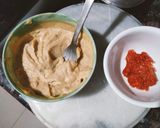 A picture of step 2 of Grilled sandwich filled with hummus, red sauce and vegetables.