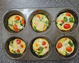 A picture of step 4 of Egg Cups With Tomato, Swiss, and Spinach.