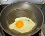 A picture of step 6 of Jah Jan Mien (instant packet noodles) with peanut butter, spring onions topped with fried egg.