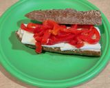 A picture of step 2 of Sandwich with 7-Grain Bread, Brie Cheese, Roasted Red Pepper Strips, and Hummus.