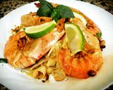 A picture of step 4 of Pad thai with king prawns and lemon slices and tagliatelle rice.