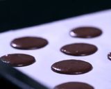 A picture of step 6 of Chocolate Macarons with a White Chocolate Ganache filling.